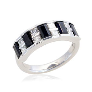 Ladies dress ring has alternating princess cut white diamonds and baguette Australian blue sapphires all channel set across top section of a wide band.